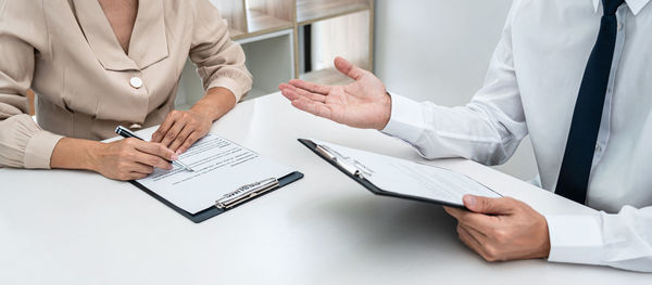 Midsection of business colleagues working on table