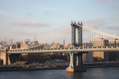 Manhattan bridge over east river in city against sky