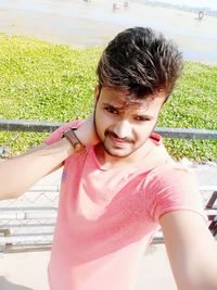 High angle view of handsome man standing by fence