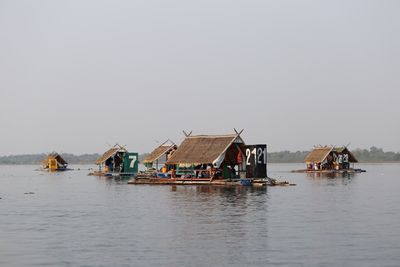 Fishing boats in lake against clear sky