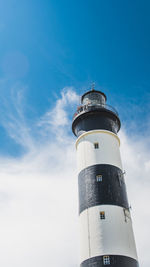 Low angle view of lighthouse by building against sky