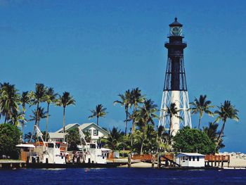 View of lighthouse by sea against clear sky