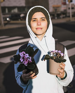 Portrait of young woman holding bouquet