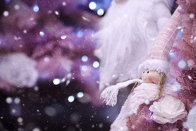 Close-up of toy doll by floral decoration during christmas