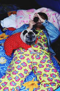 Portrait of woman with dog relaxing on bed