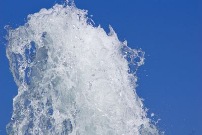 Close-up of frozen water against clear blue sky