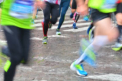 Low section of people running on street