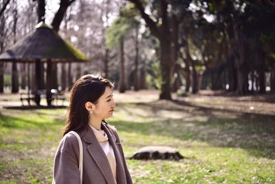 Portrait of woman standing by tree