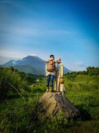 People on mountain against sky