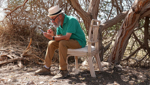 Senior man using smart phone in the desert 