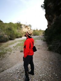 Full length of man standing on footpath against sky