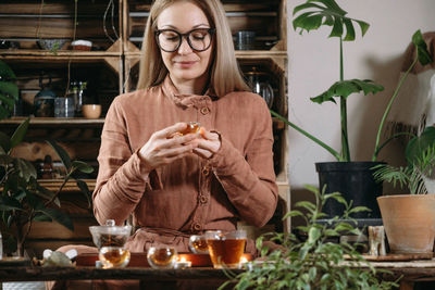 Women preparing tea ceremony in boho style atmospheric room warm drink in hands oolong chinese drink