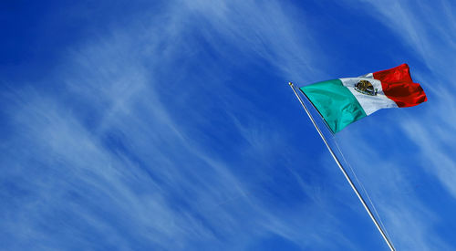 Low angle view of flag against blue sky