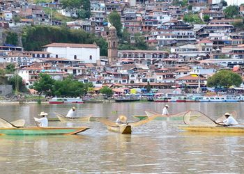 Boats in lake by buildings in town