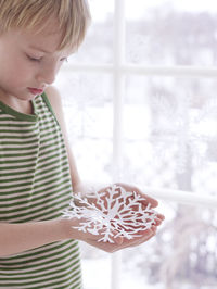 Boy holding snowflake decoration