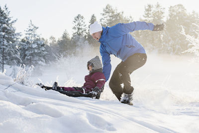 Father with daughter sledging