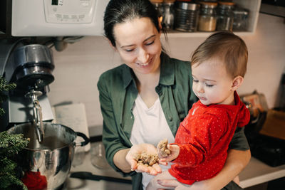 Cozy christmas at home. family preparation holiday dessert. mother and baby toddler daughter play