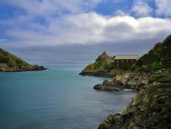 Scenic view of sea by buildings against sky