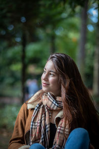 Portrait of young woman looking away outdoors