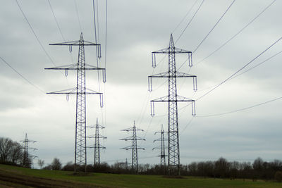 Electricity pylon on field against sky