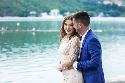 Couple standing against lake