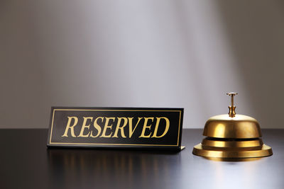 Close-up of reserved place card with service bell on table