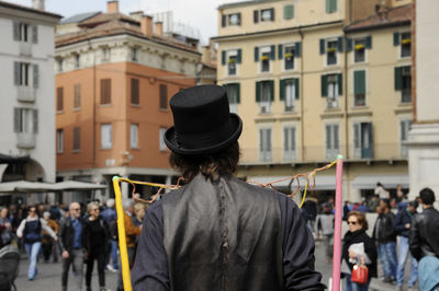 Rear view of people standing on street in city