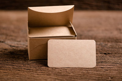 Close-up of visiting cards with box on wooden table