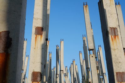 Low angle view of construction site against clear blue sky