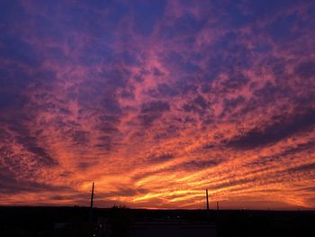 Low angle view of silhouette building against dramatic sky