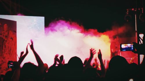 Crowd at music concert against sky at night