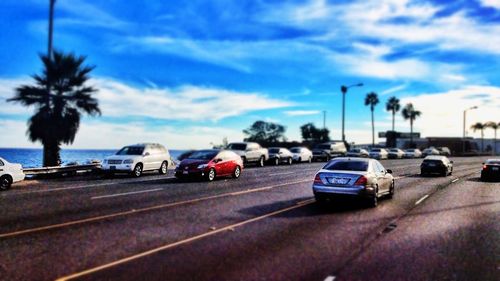Cars on road against cloudy sky