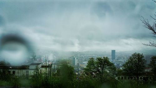 Buildings in city against cloudy sky