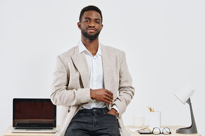 Portrait of businessman standing against white background