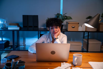 Young woman using laptop at table