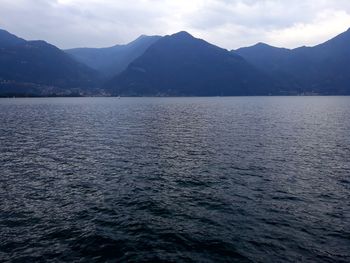 Scenic view of sea by mountains against sky