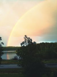 Scenic view of rainbow over lake against sky