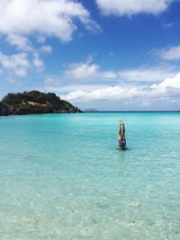 Low section of man in sea against sky