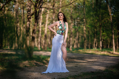 Full length portrait of woman standing in forest