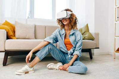 Portrait of young woman sitting on sofa at home