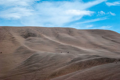 Scenic view of desert against cloudy sky