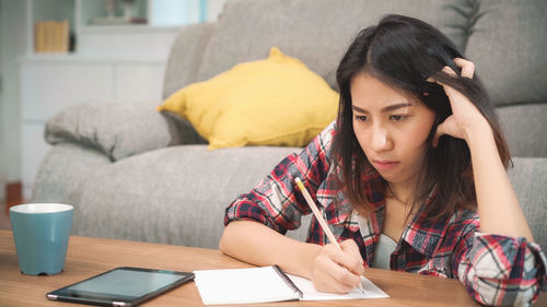 Young woman using mobile phone at home