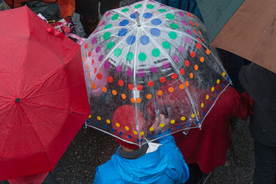 High angle view of people with multi colored umbrella on street