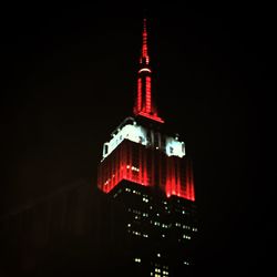 Low angle view of communications tower against sky at night