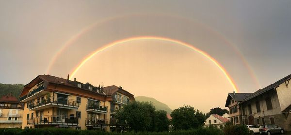 Scenic view of rainbow over buildings against sky