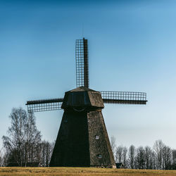 Traditional windmill on field against sky