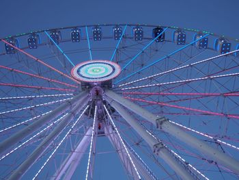 Low angle view of ferris wheel against blue sky