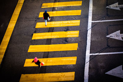 High angle view of yellow crossing sign on road