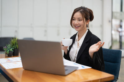 Businesswoman using laptop at table