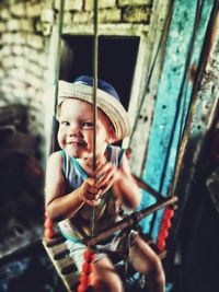 Portrait of cute boy sitting on swing